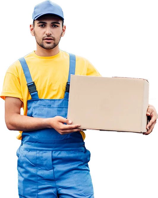 A man in a yellow t-shirt and blue overalls standing while holding a cardboard box, symbolizing moving or relocation services.